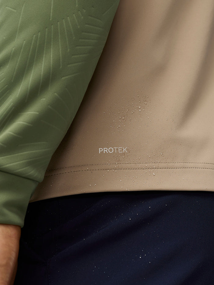Close-up of ProTek fabric on beige panel with green sleeve from the Golf Pinnacle gilet