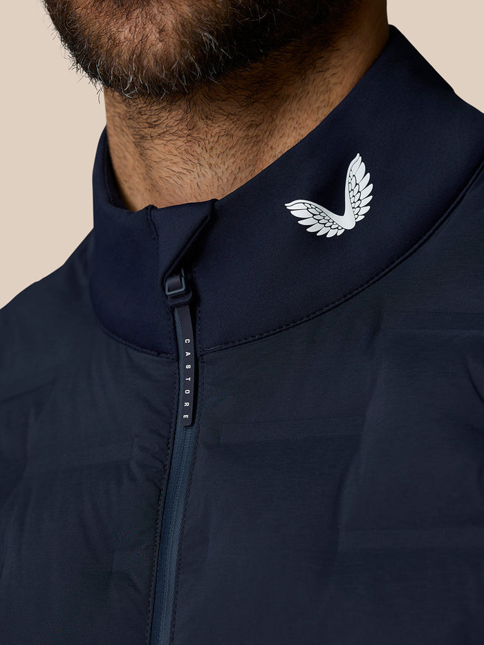 Close-up of the navy gilet collar with Castore logo and front zip pull