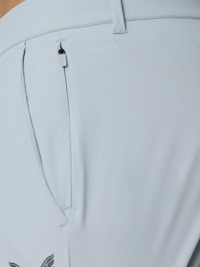Close-up of back pocket area with ProTek branding on light grey Castore golf trousers.