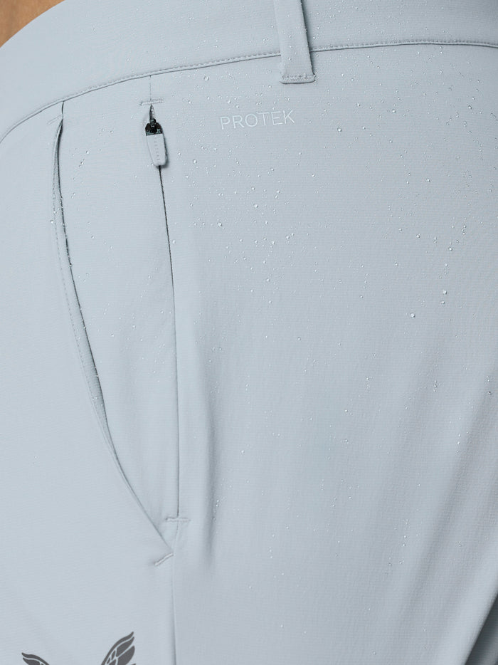 Light grey Golf Pinnacle trousers close-up with back pocket belt loop and water repellent fabric with droplets.
