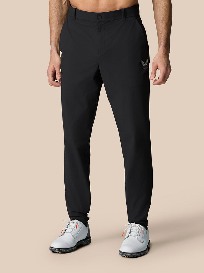 Close up of male model wearing black Golf Pinnacle trousers showing the waistband and tapered fit