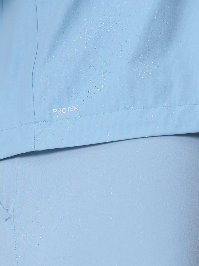 Close-up of water droplets on sky blue jacket fabric showcasing ProTek water resistance.