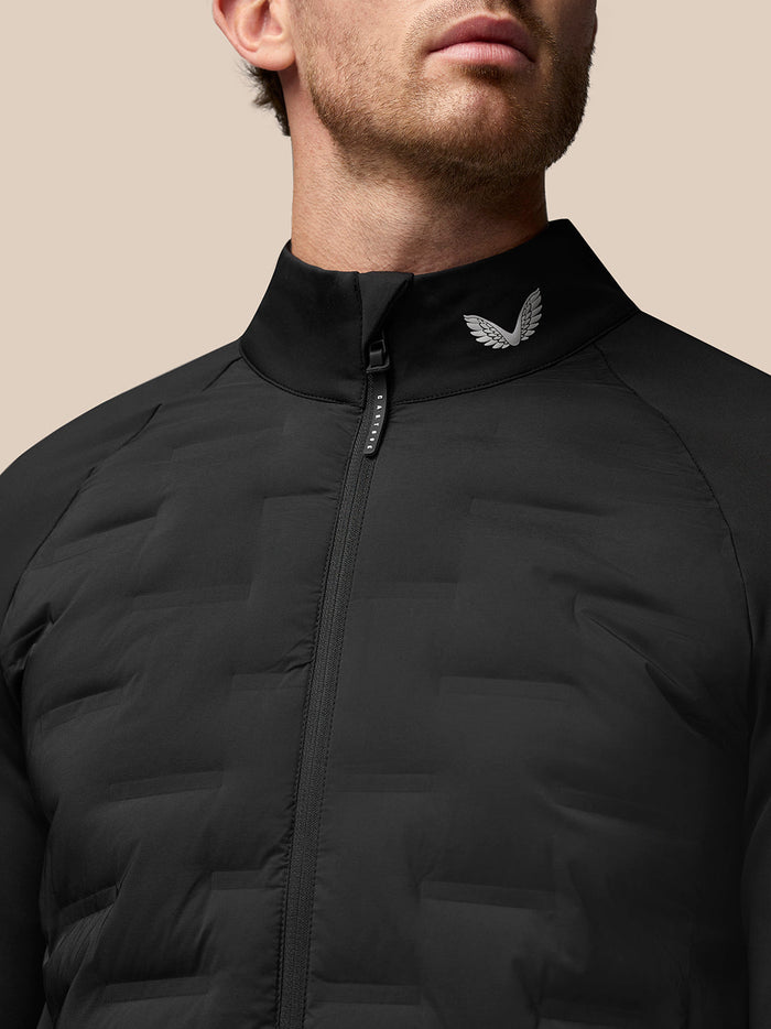 Close-up of the black jacket collar with a metallic wing logo and zip detail.