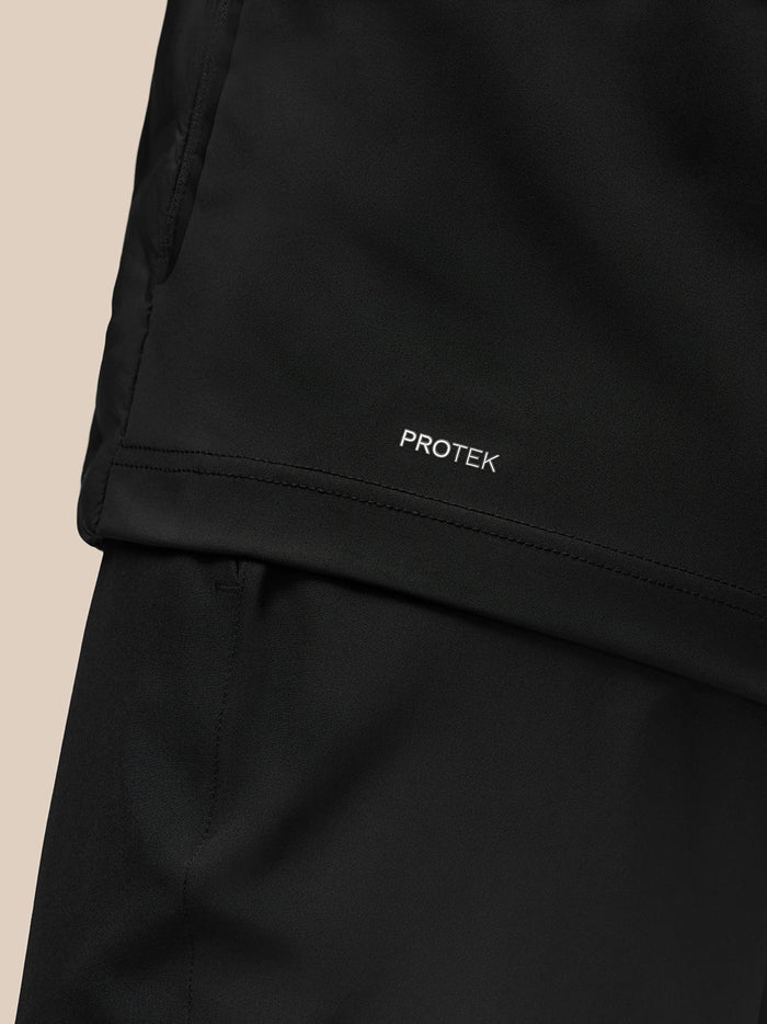 Close up of black Pinnacle Golf Jacket fabric with PROTEK label.