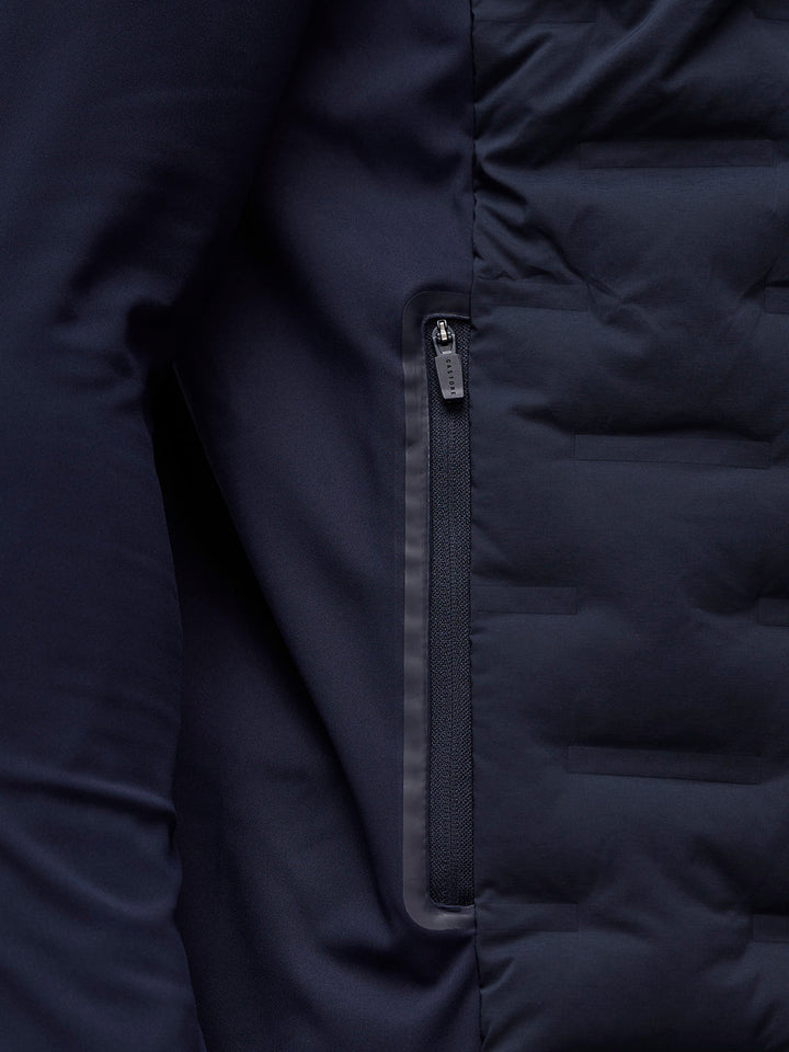 Detail of navy Golf Pinnacle Jacket with quilted front panels and Castore logo on the collar