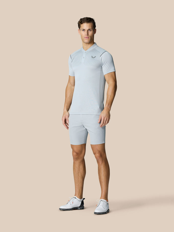 Full body view of male model in Pinnacle Golf LVS Polo with matching light grey shorts and white golf shoes.