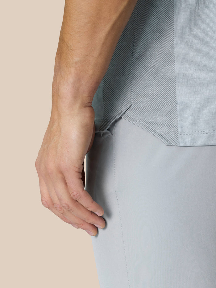 Side view of model wearing Pinnacle Golf LVS Polo in mid grey highlighting side panels and knit texture.