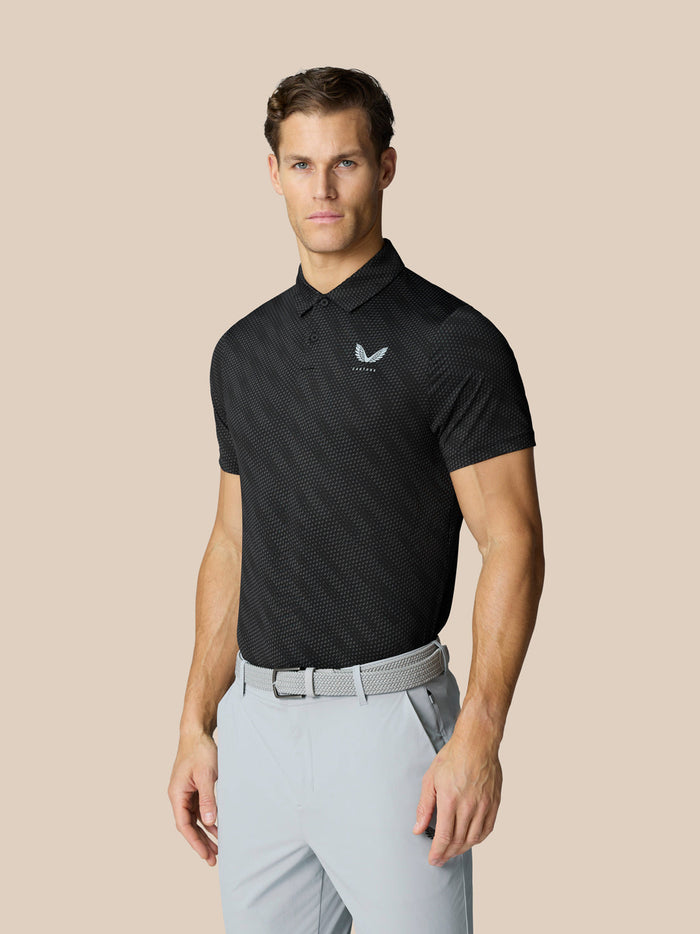 Male model wearing black Club Graphic Polo with golf ball print and short sleeves.