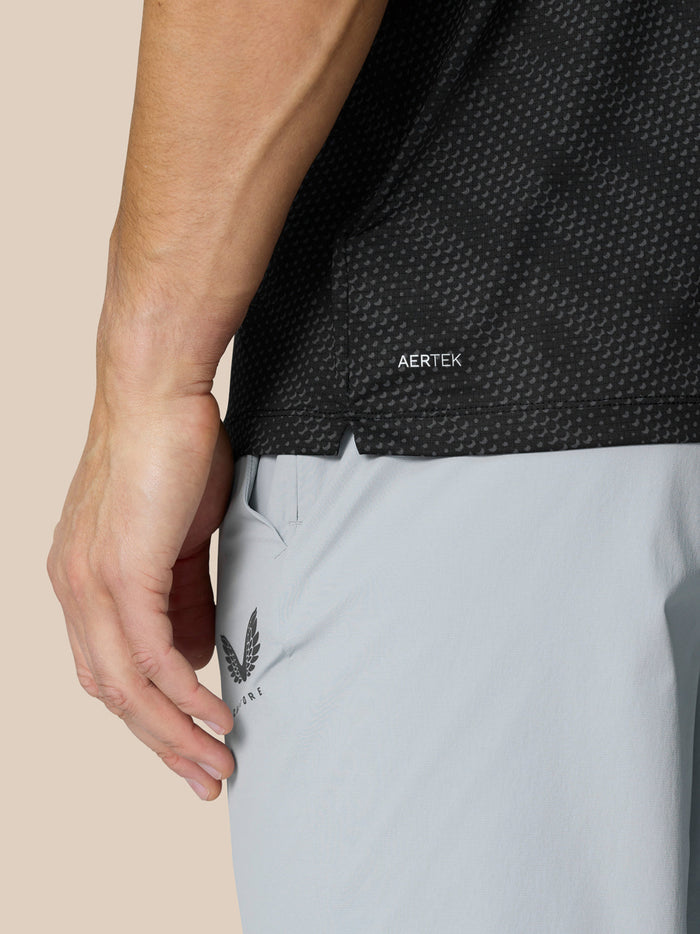 Close up of black dotted polo showing AERTEK label at hem
