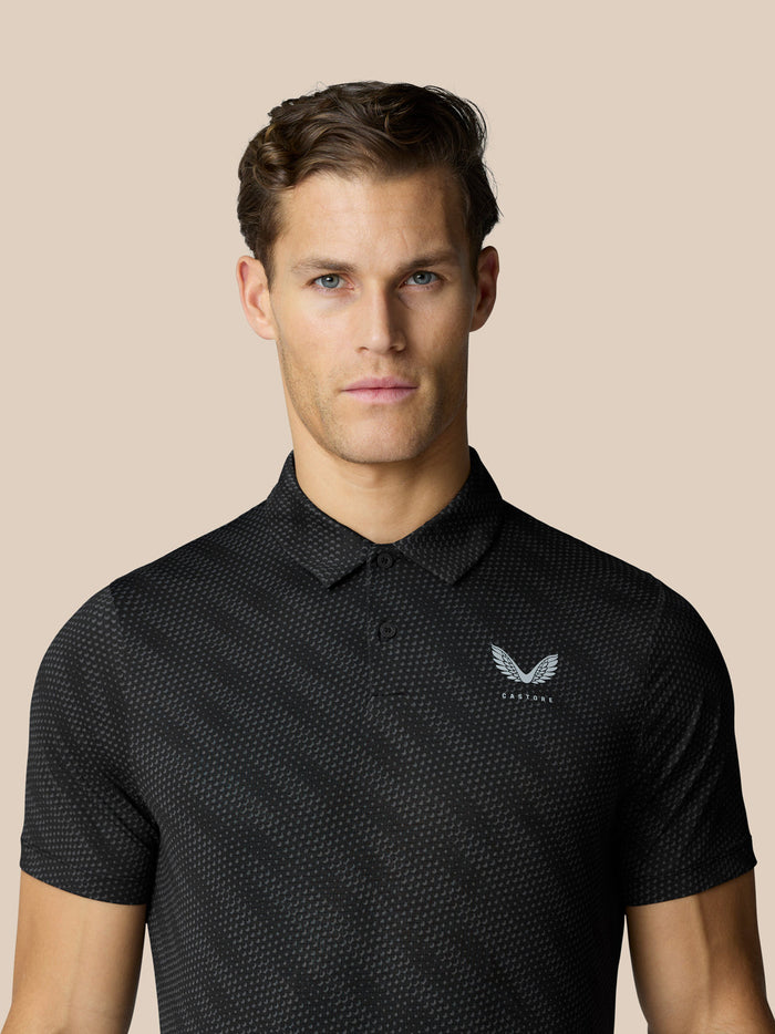Close-up of a man wearing the black Club Graphic Polo showing a dotted pattern and chest logo.