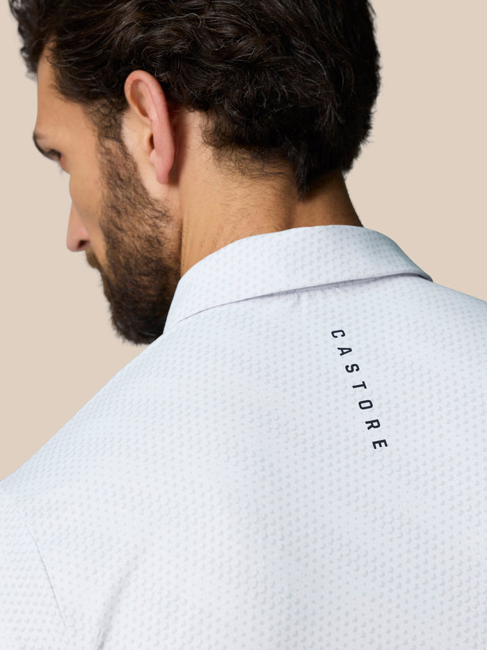 Back view of a man in a white Club Graphic Polo showing CASTORE branding along the upper back.