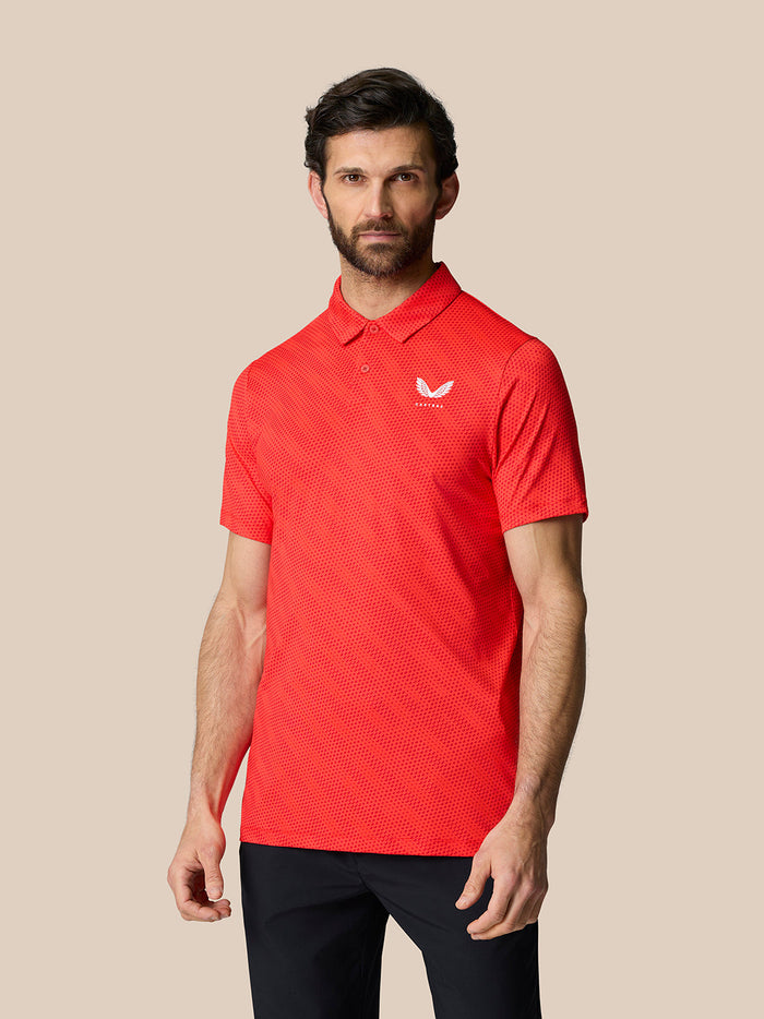 Three-quarter profile of a man in the red Club Graphic Polo, highlighting the dotted texture and fitted silhouette.