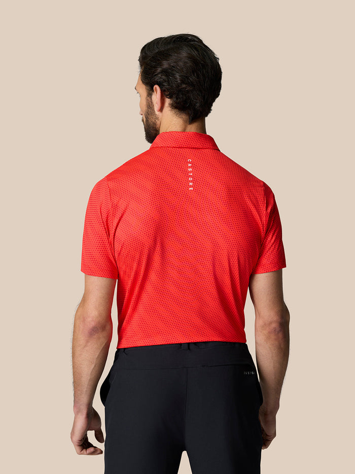 Back view of a man in a red perforated polo with Castore branding on the upper back.