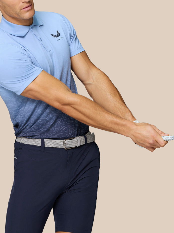 Golfer in Sky Blue Club Graphic Polo mid swing, gradient ombre print and Castore logo on chest.