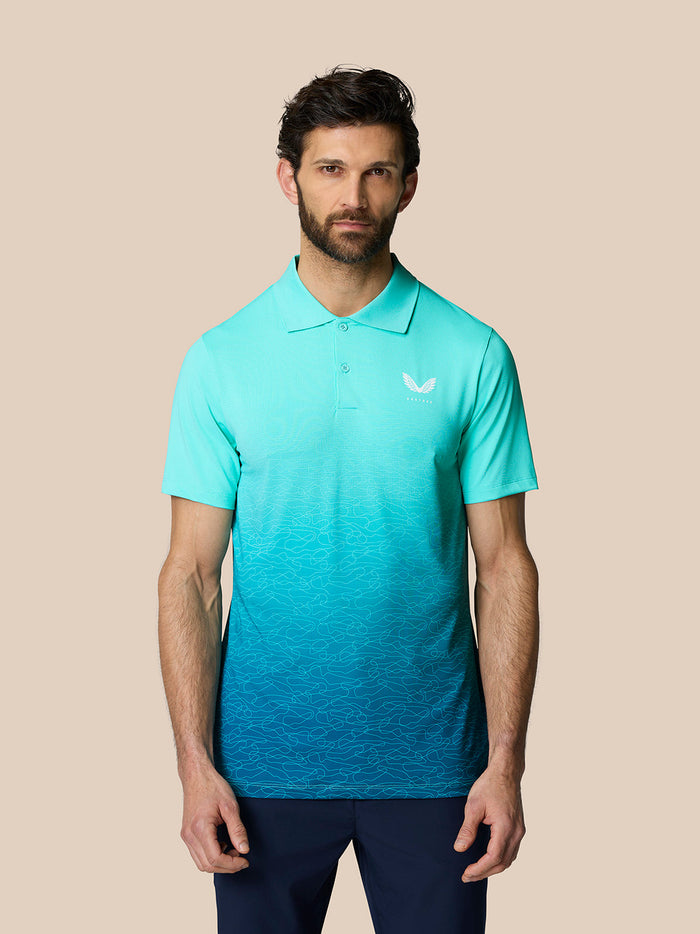 Front three-quarter view of a man wearing light aqua Club Graphic Polo with gradient pattern from chest to hem and Castore logo on chest.