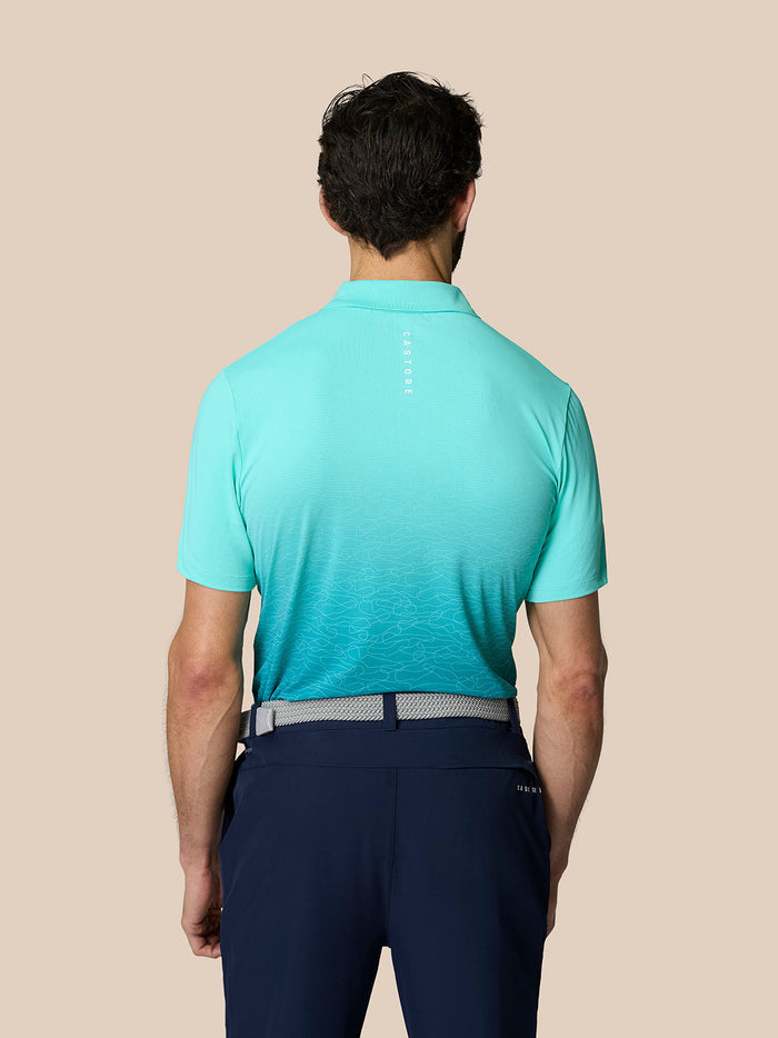 Back view of male model wearing light aqua Club Graphic Polo with Castore branding on upper back.