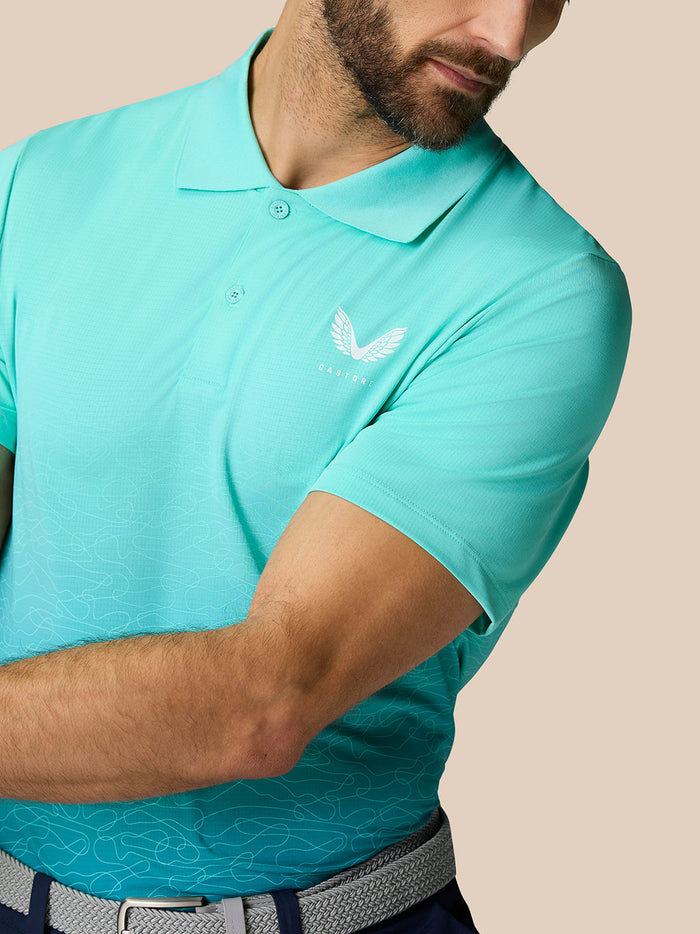 Close-up of Club Graphic Polo in light aqua highlighting Castore logo on left chest and ombre wave pattern.