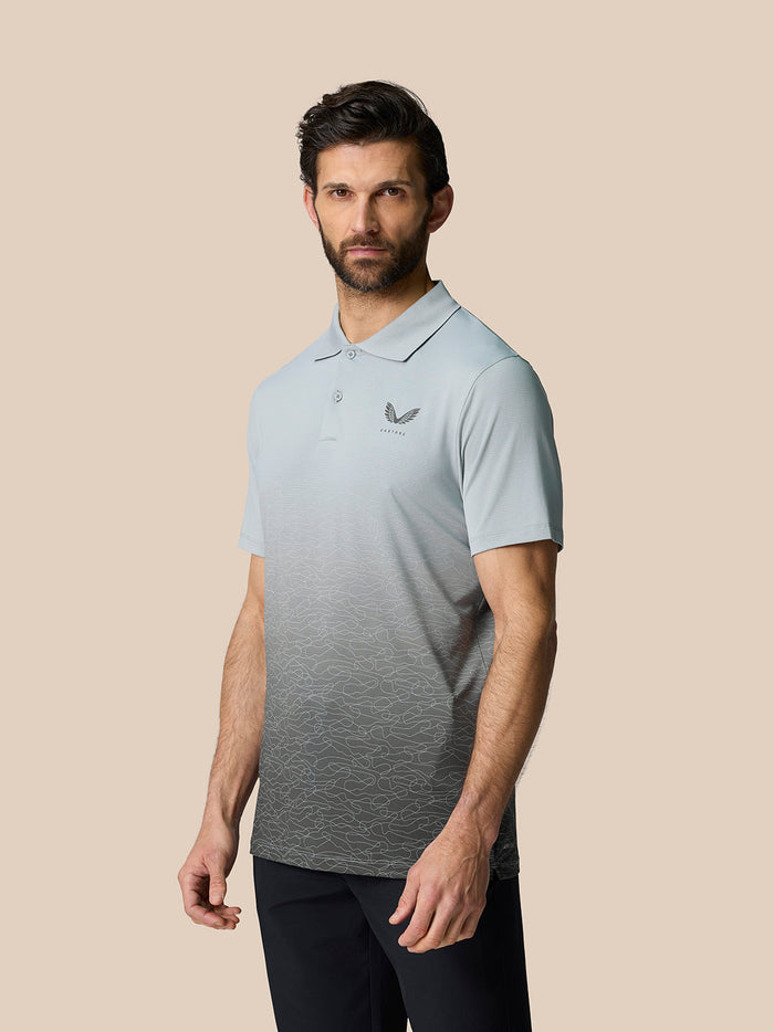 Male model wearing Club Graphic Polo in mid grey with an ombre wave pattern and Castore branding on the chest and upper back.