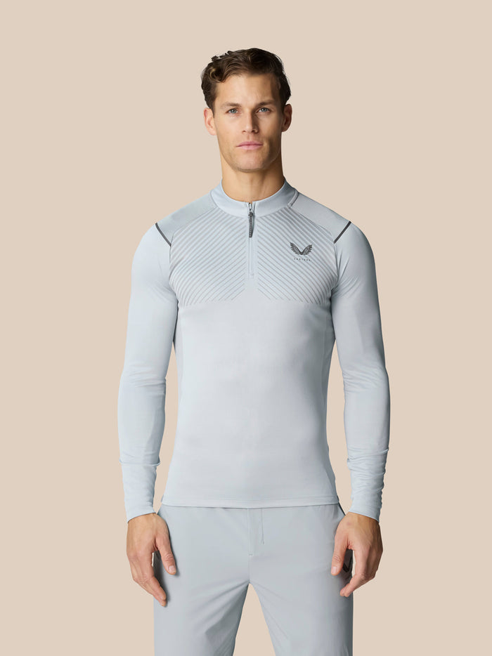 Model wearing Pinnacle LVS quarter zip top in mid grey with venting stripes and Castore logo