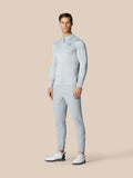 Full body shot of a man in light grey Pinnacle LVS 1/4 Zip Top with matching pants against a beige backdrop