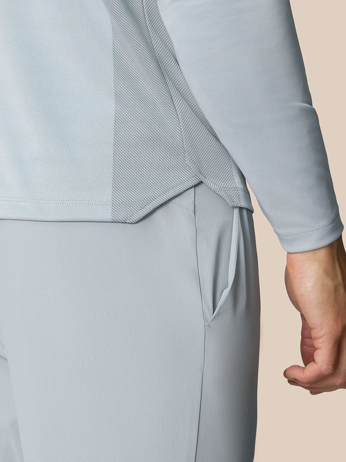 Close-up of Pinnacle LVS 1/4 Zip Top fabric showing textured knit panels and curved hem seam