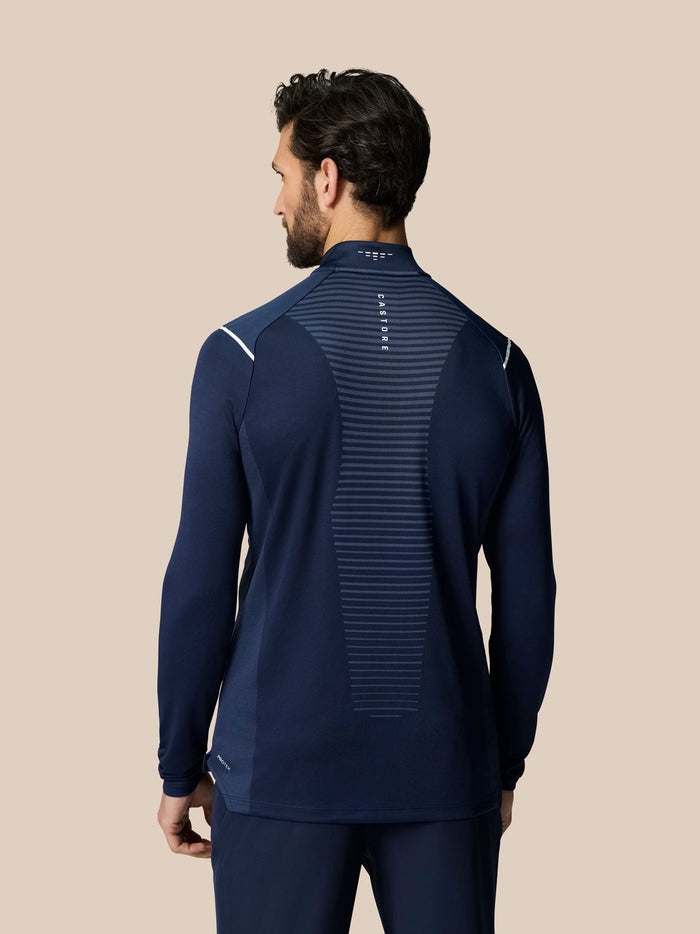 Back view of a man wearing navy Pinnacle LVS 1/4 Zip Top with a central striped vent panel.