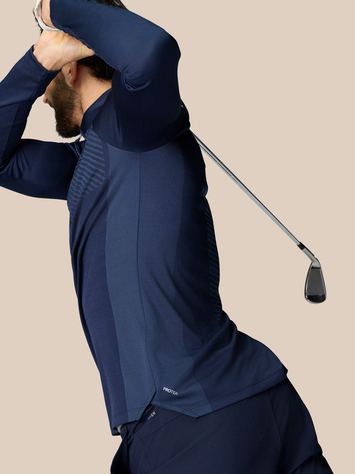 Side view of a man in navy LVS 1/4 Zip Top showing mesh panels and a golf club in the frame.