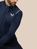 Model wearing navy Pinnacle LVS 1/4 Zip Top with striped chest panel and white Castore logo