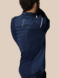 Three quarter back view of a man in navy Pinnacle LVS 1/4 Zip Top lifting his arm to reveal vented side panels.
