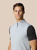 Portrait of a man in a light grey high neck golf gilet with half zip and a dark dotted underlayer at the sleeves