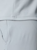 Close-up of light grey Castore golf gilet fabric with water droplets and ProTek branding