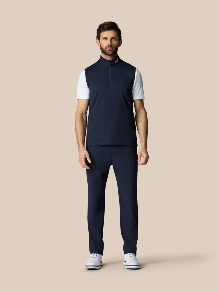 Full-body view of male model in navy Club 1/2 Zip Gilet with matching navy pants and white sneakers.