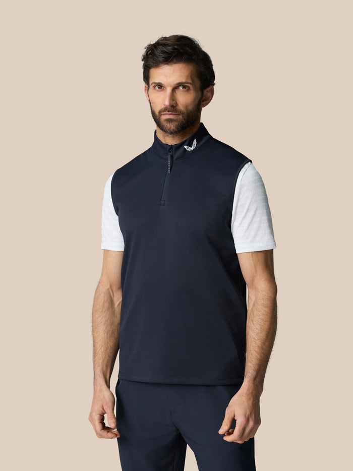 Male model wearing navy Club 1/2 Zip Gilet with high collar and half-zip, sleeveless over a white tee