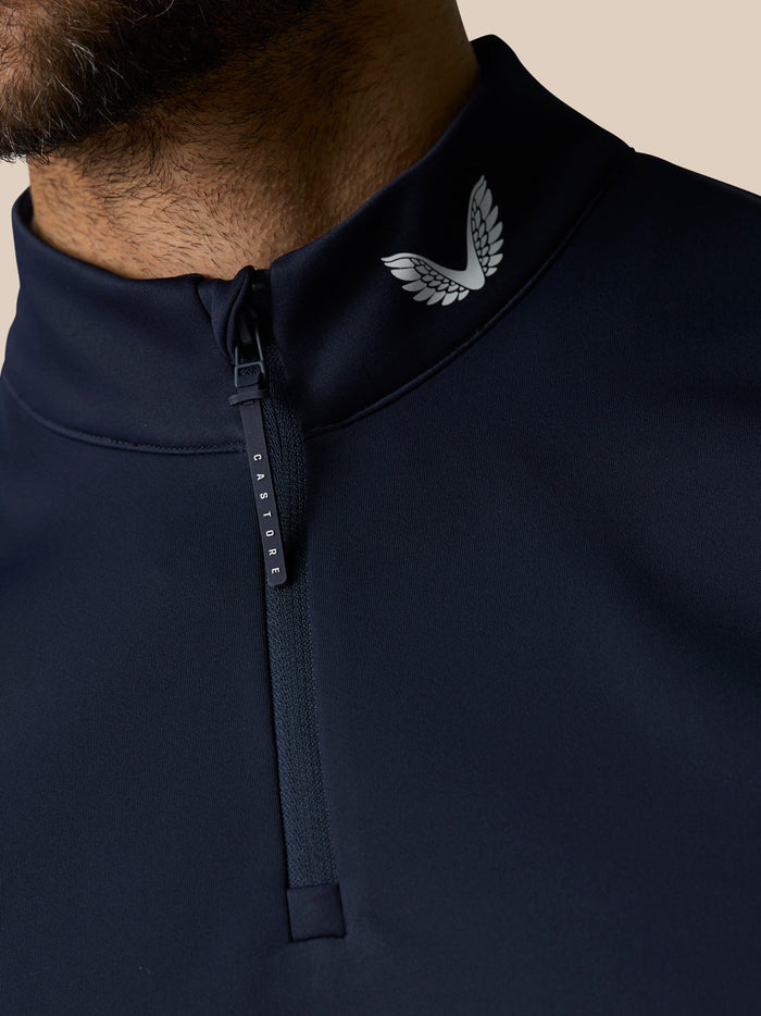 Close-up of navy Club 1/2 Zip Gilet collar with a white wing logo and CASTORE zip pull