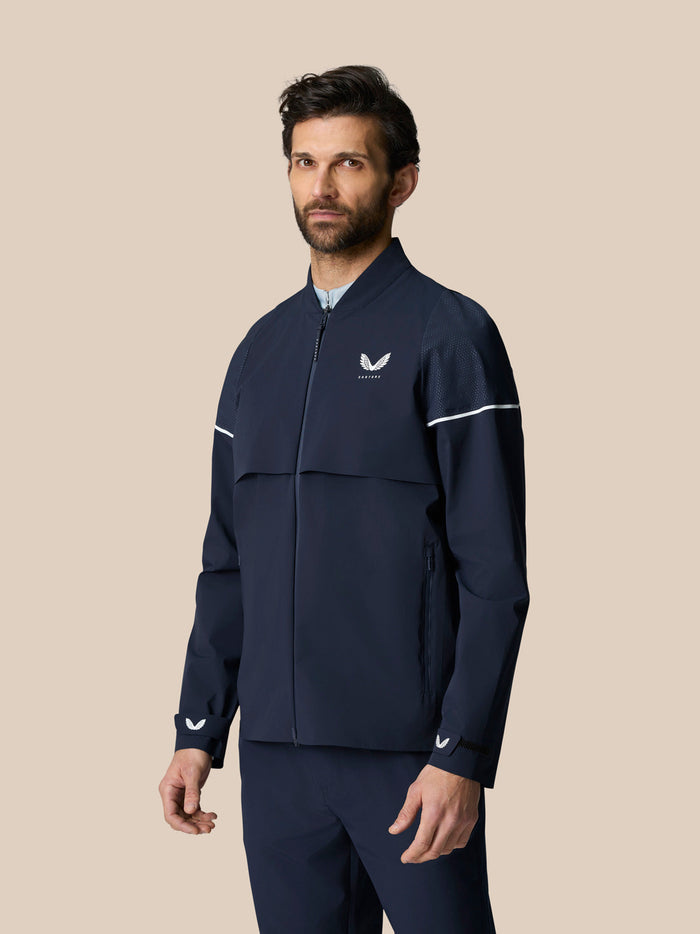 Front view of a man wearing Golf Pinnacle LVS Woven Jacket in Midnight Navy with chest logo and sleeve stripes