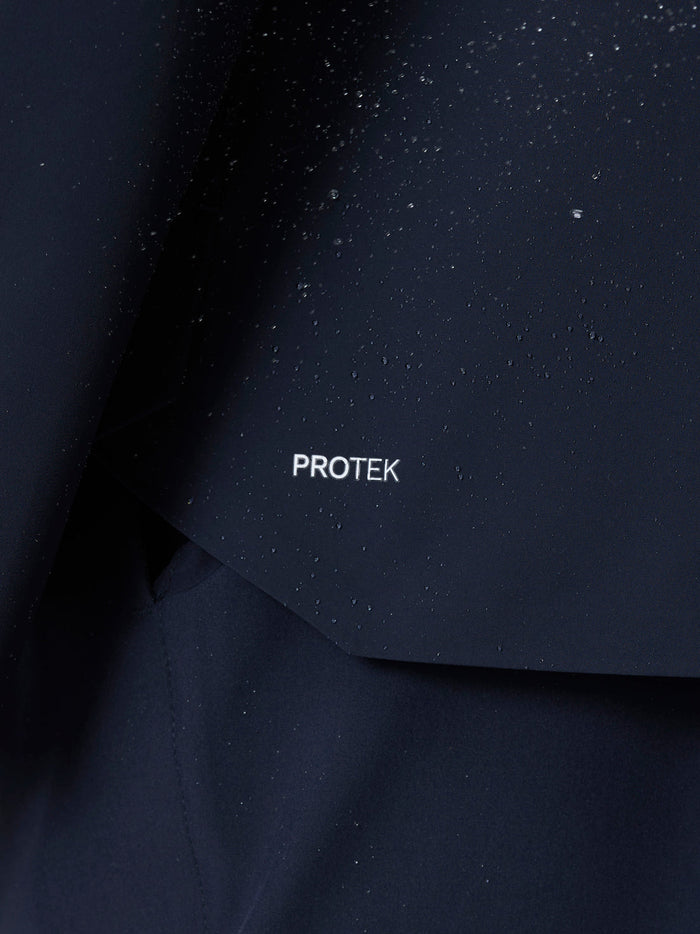 Close up of ProTek fabric on the Midnight Navy jacket with water droplets on the surface.
