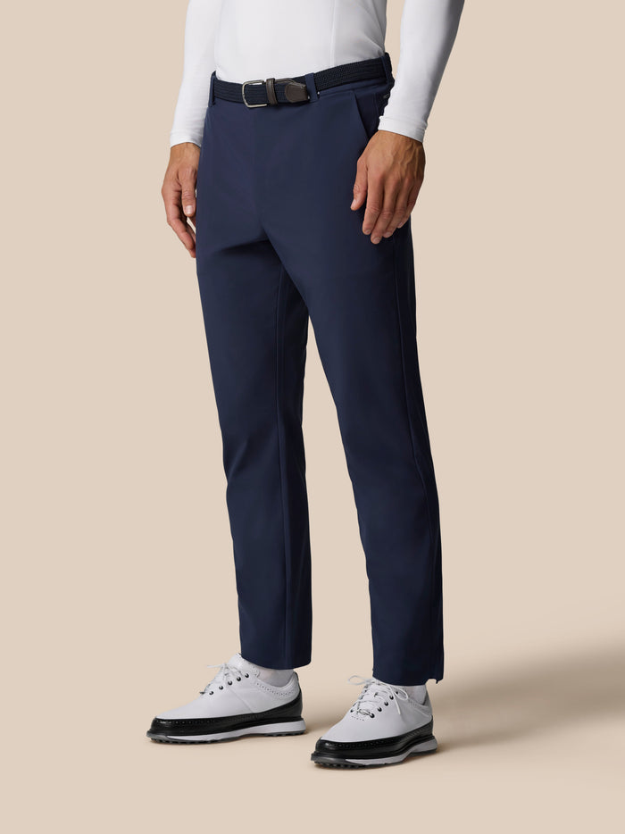 Close up of navy golf winter trousers at the waist with a black belt and white shirt