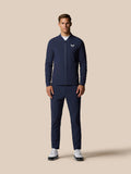 Male model wearing navy golf winter jacket and matching trousers with Castore logo on chest