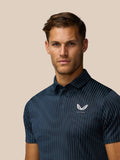 Close-up of midnight navy Golf Pinnacle Glow Polo showing striped knit and left chest Castore logo.