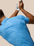 Back view of a golfer in a Cool Blue Glow Printed Polo with CASTORE branding across the upper back