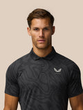 Close-up of a man wearing a gunmetal grey striped golf polo with Castore logo on the left chest.