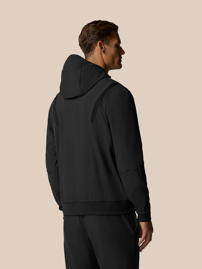 Back view of a man in a black hooded jacket highlighting the three panel hood and athletic fit