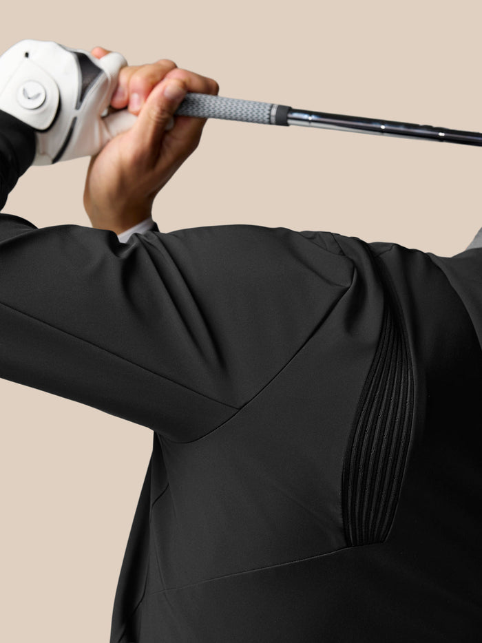 Golf Pinnacle Performance Hoodie worn by a golfer gripping a golf club