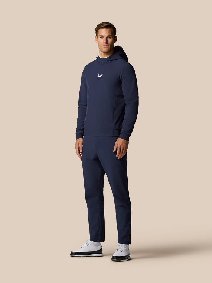 Front view of a man wearing Midnight Navy Golf Pinnacle Performance Hoodie with chest logo