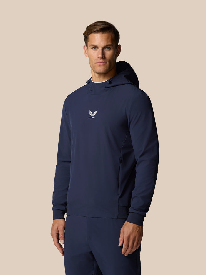 Three quarter view of a man wearing Midnight Navy Golf Pinnacle Performance Hoodie with chest logo
