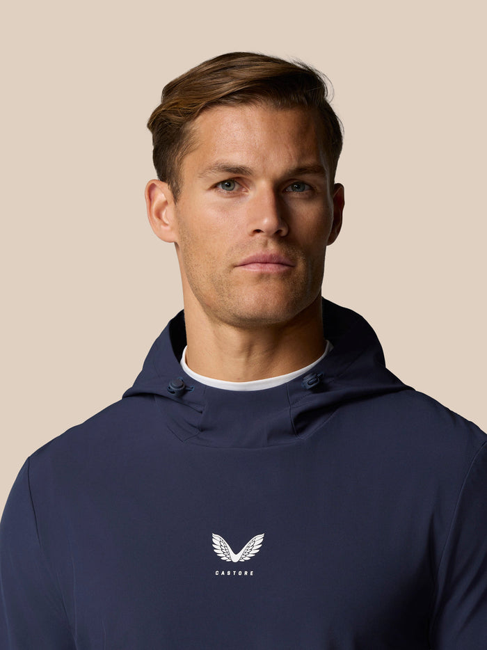 Male model wearing midnight navy Golf Pinnacle Performance Hoodie with Castore logo centered on the chest