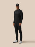 Athlete in a black Castore LVS top mid golf swing with back branding and vent signifier