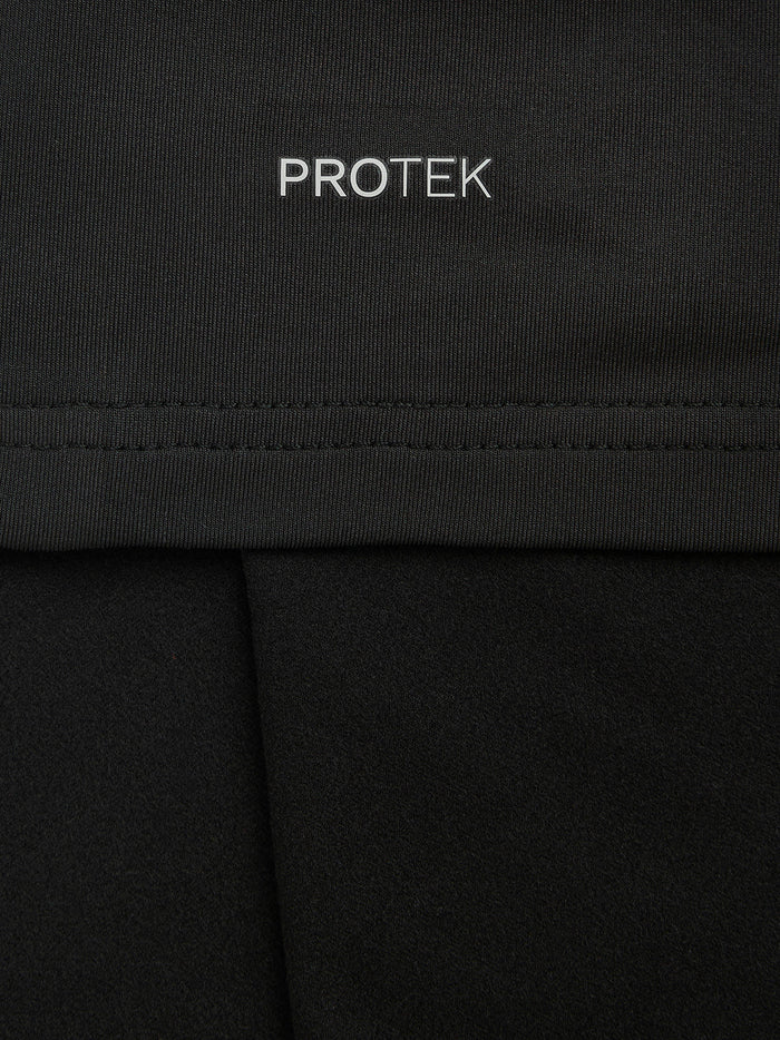 Close-up of black fabric with PROTEK branding and a stitched seam.