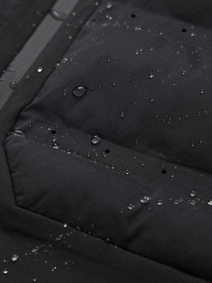 Close-up of water droplets on black jacket fabric with a visible zipper and seam.