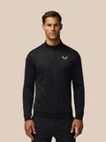 Man in black all over print golf top with quarter zip and small Castore logo on the chest.